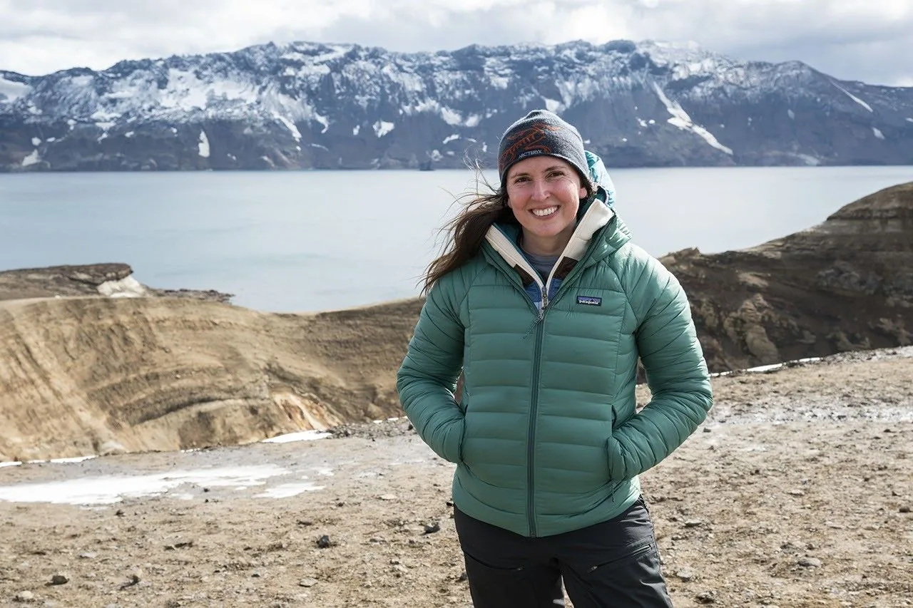 NASA planetary geologist Kelsey Young stands in rugged terrain during geological fieldwork.