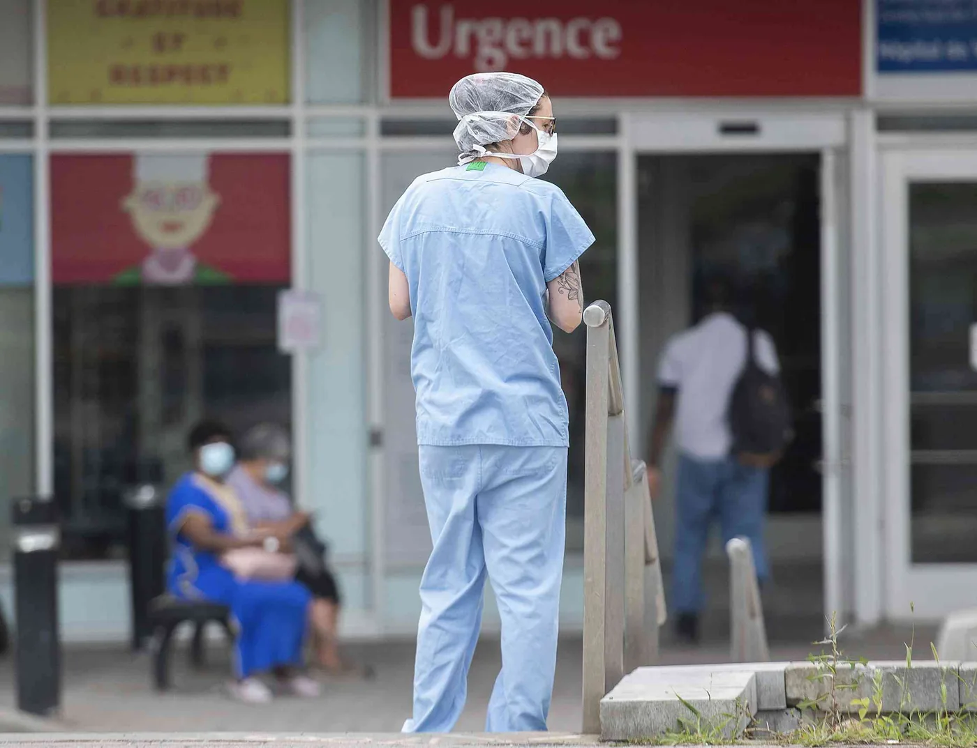 A healthcare worker outside a hospital demonstrating the challenges of chronic pain at work in physically demanding roles.