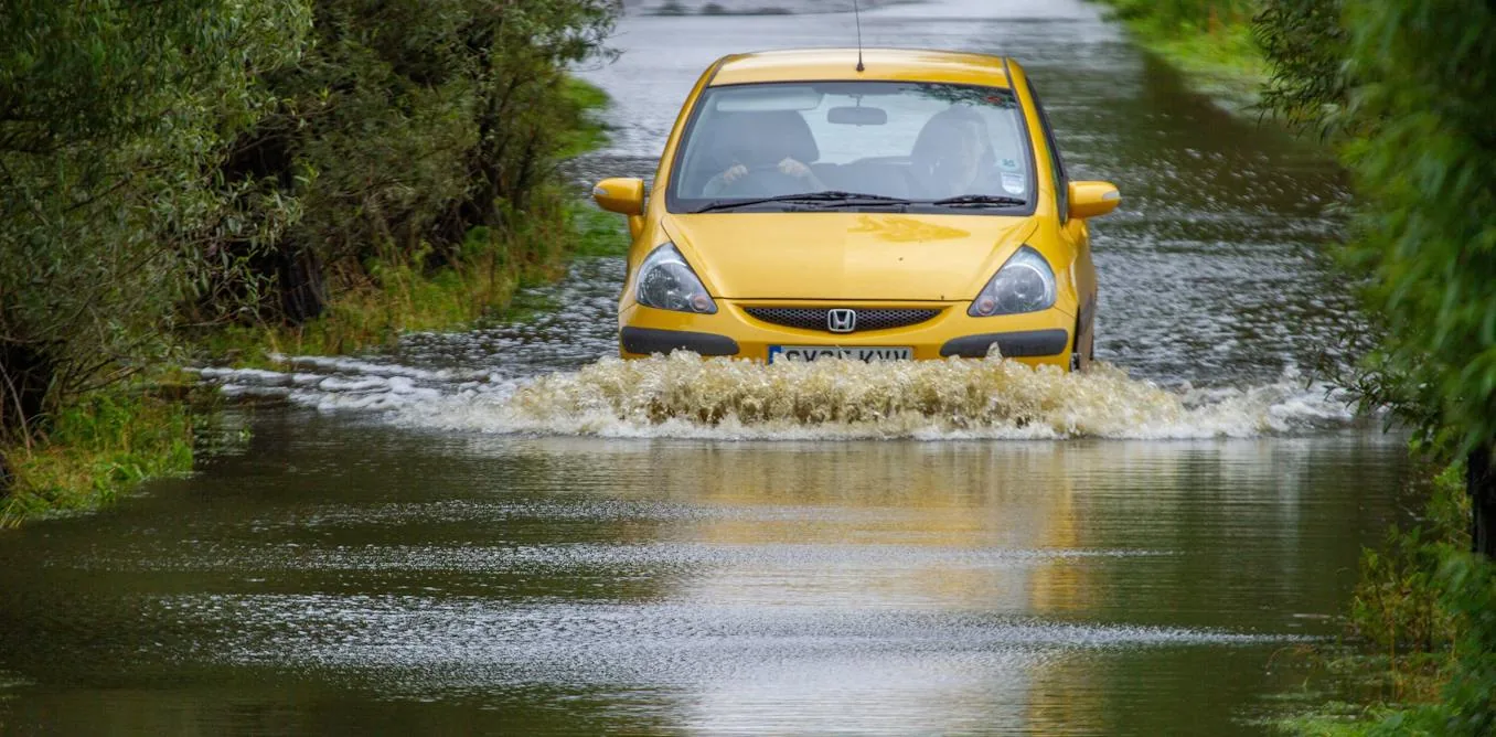 Submerged roadway highlighting why driving through water poses severe risks to motorists.