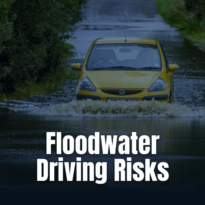 A passenger car submerged in rising floodwater illustrates the hazards of driving through water during severe weather.