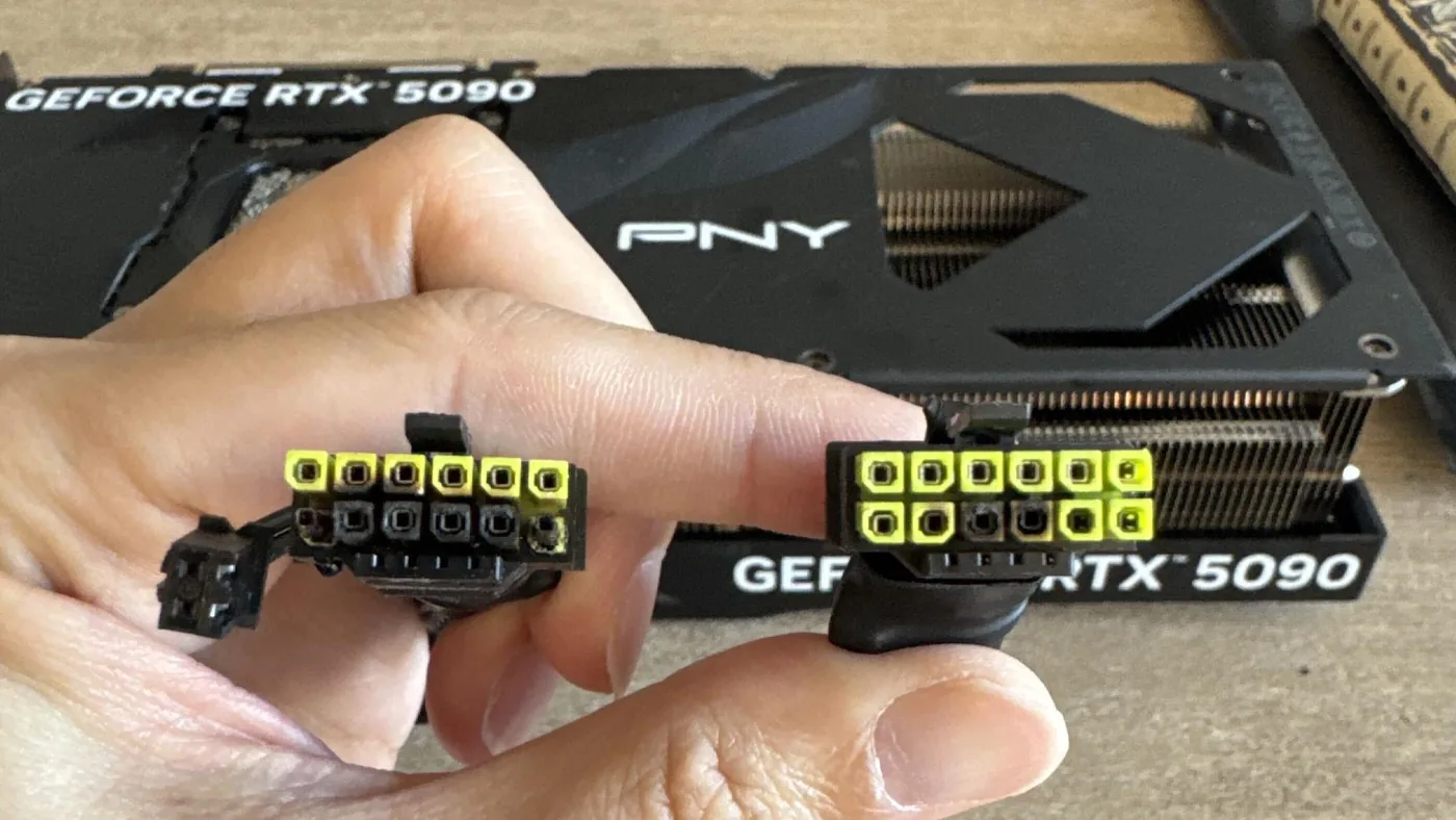 A PNY GeForce RTX 5090 graphics card alongside power adapter cables.