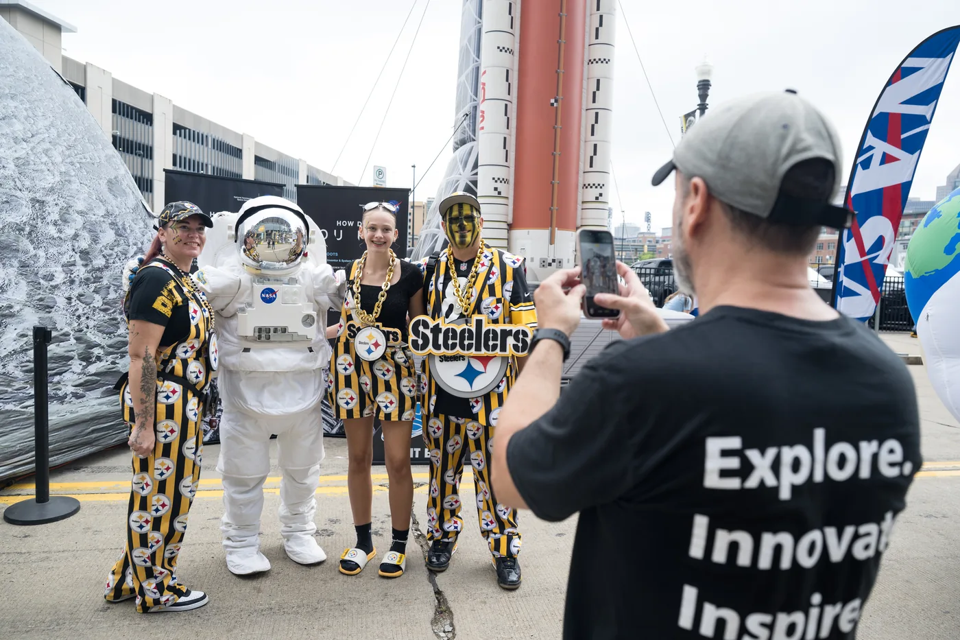 An astronaut and visitors inside the NASA Inspiration Tour exhibit at Acrisure Stadium in Pittsburgh.
