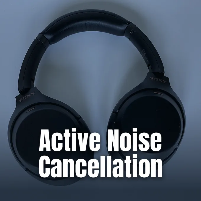 A pair of black over-ear noise-cancelling headphones resting upright against a neutral background.