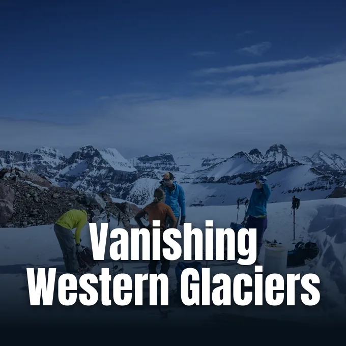 Researchers standing on a snowy mountain ridge surrounded by rugged peaks conducting glacier fieldwork.