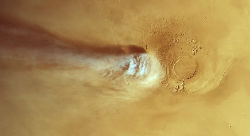 Atmospheric plume extending over the Martian landscape downwind from the volcanic summit.