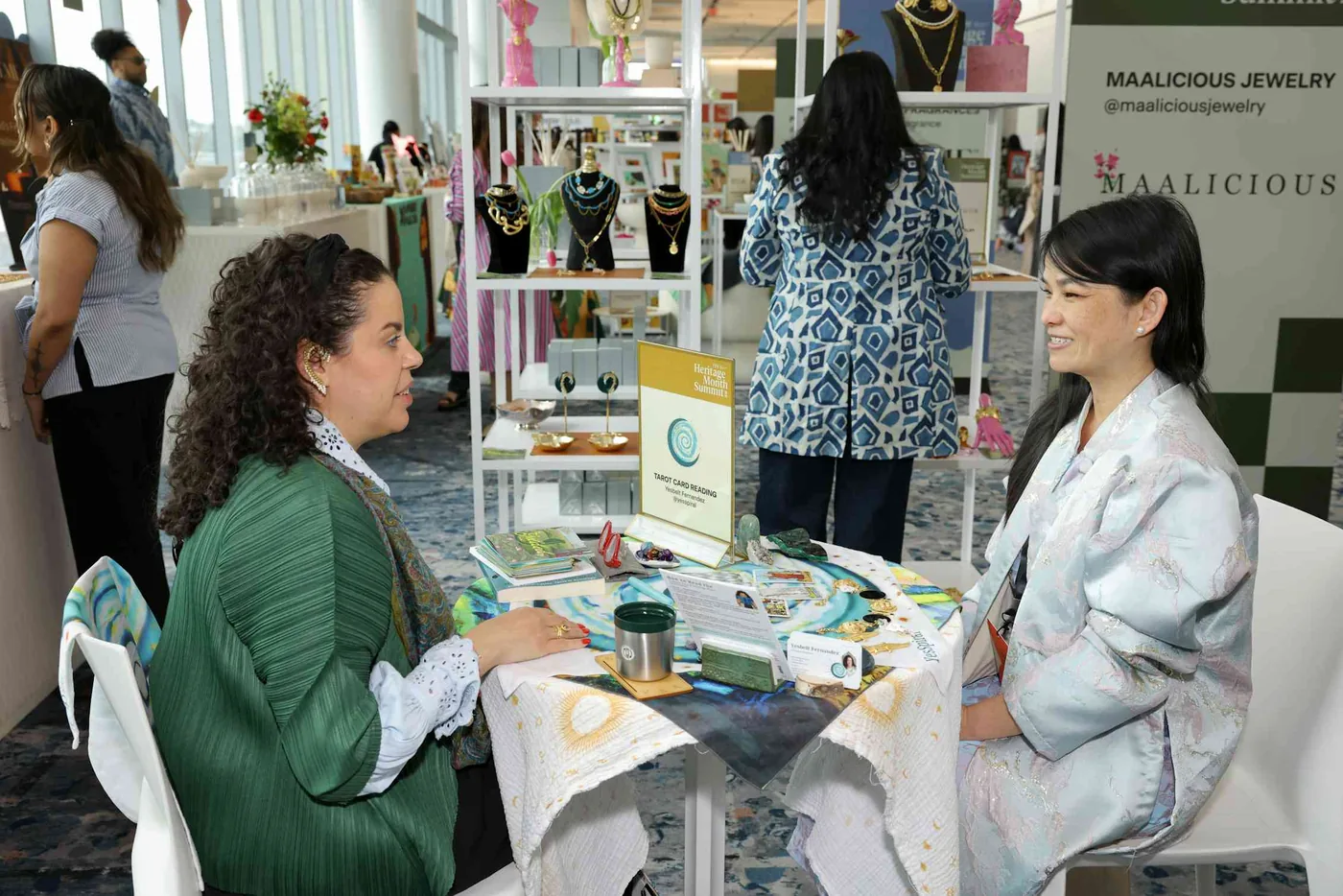 Two people seated at a table offering a tarot card reading illustrating belief in magic.