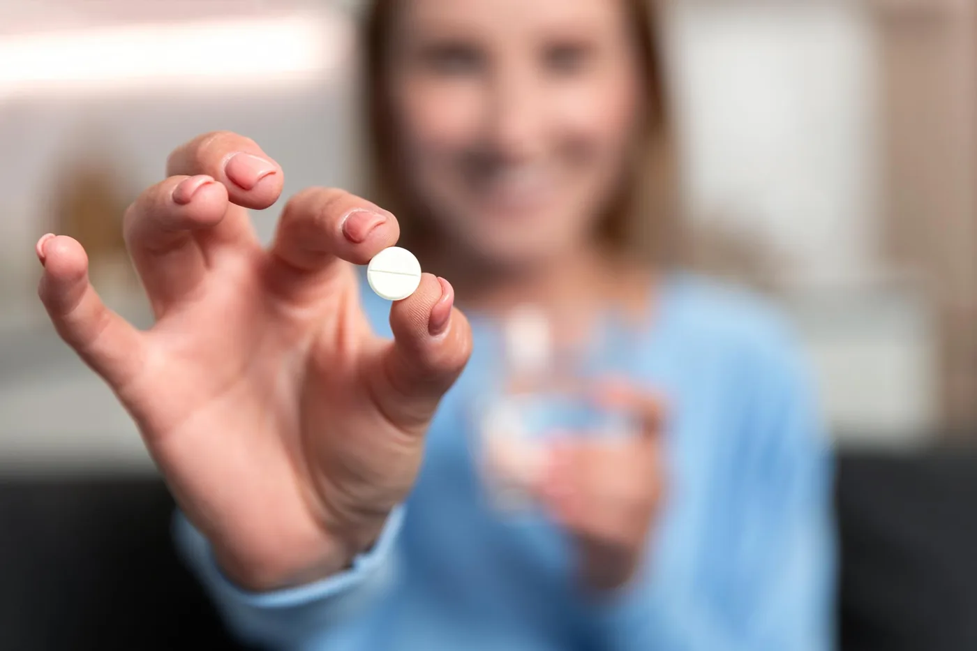 Patient holding a white prescription pill representing blood pressure treatments