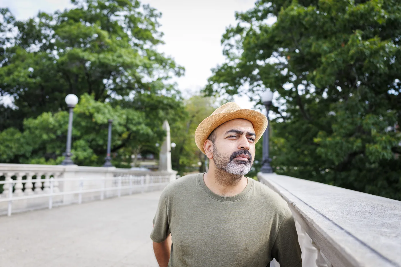 Boston University graduate Leo Moradi standing on the Weeks Footbridge above the Charles River.