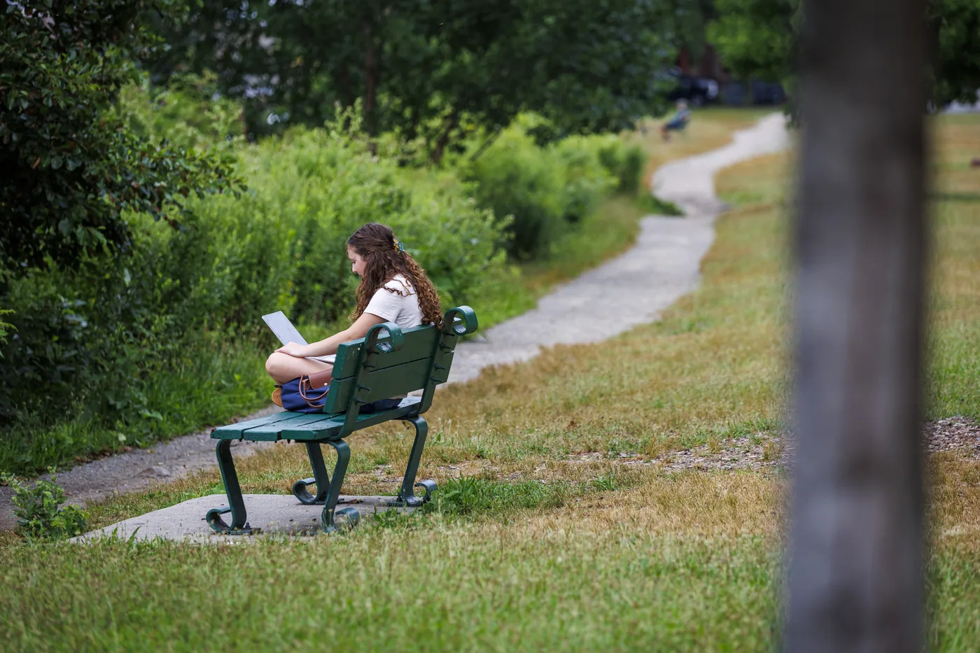 Harvard Summer School student Ellie Stallings studying near the Charles River.