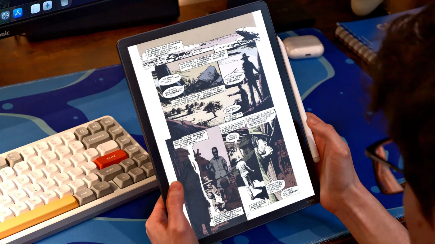 Amazon Kindle Scribe Colorsoft displayed above a desk displaying a comic book page.