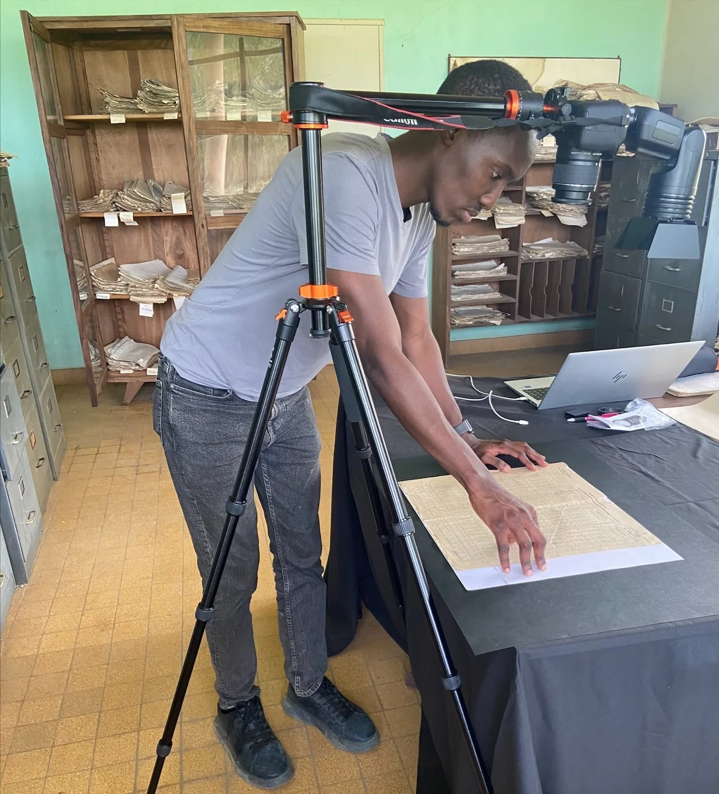 Derrick Muheki and colleagues photographing handwritten weather documents
