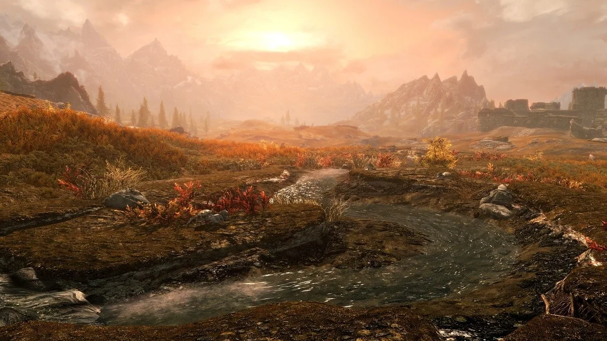 A setting sun illuminating a river landscape in Skyrim.