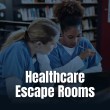 Two healthcare students wearing blue scrubs collaborate and study together at a desk.