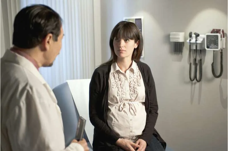Pregnant woman consulting a doctor about prenatal test results and diagnostic procedures.