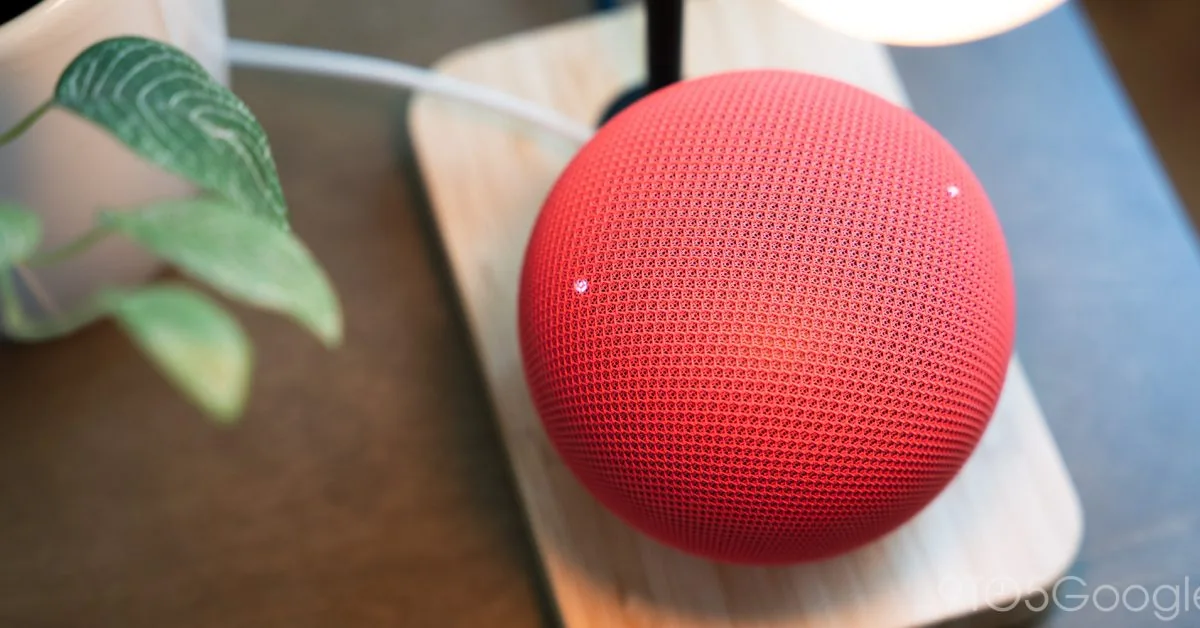 Google Home speaker standing on a wooden surface.