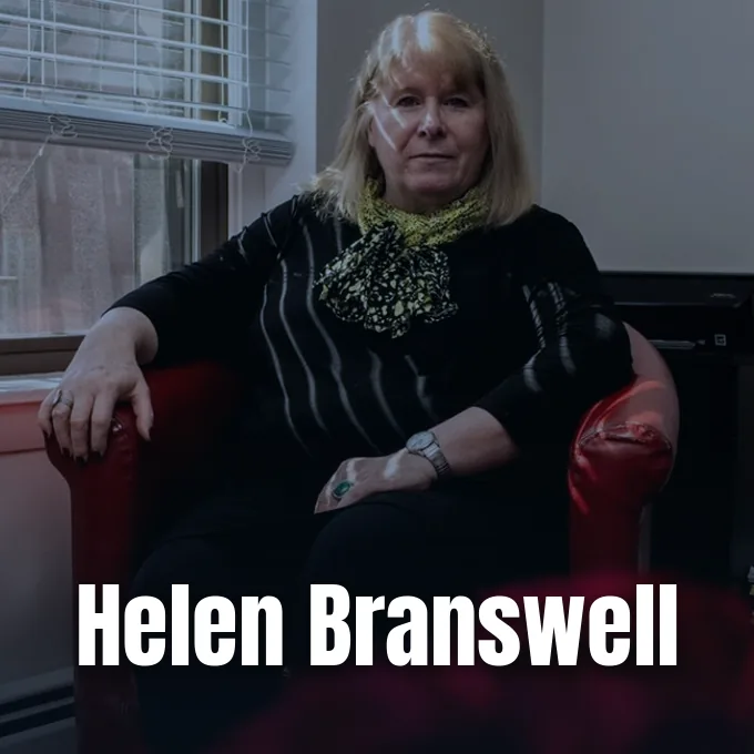 A portrait of journalist Helen Branswell seated indoors on a red armchair by a window.