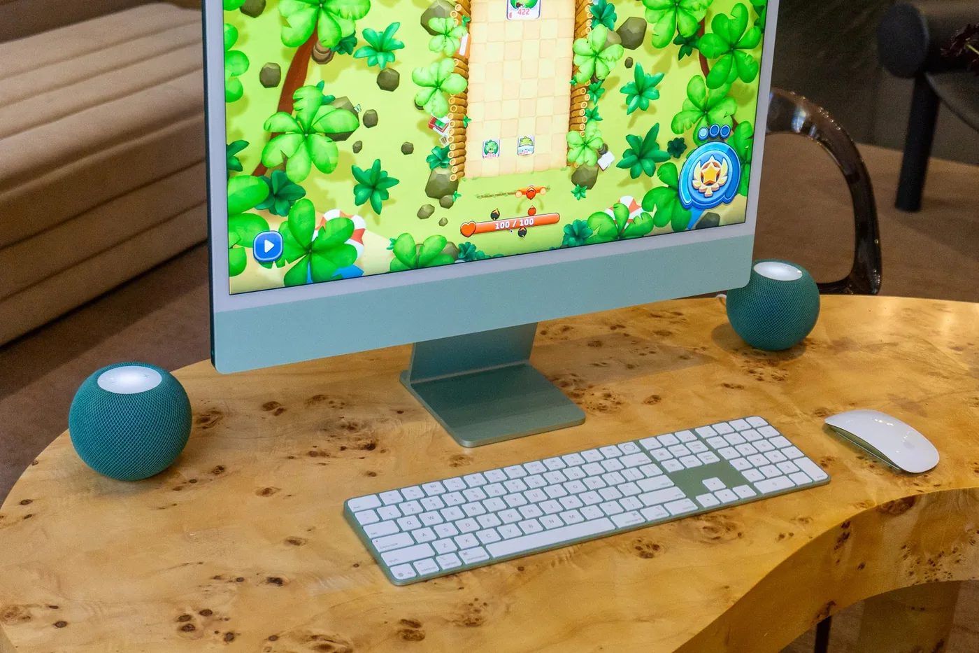 Two HomePod mini 2 units sitting next to an iMac computer.