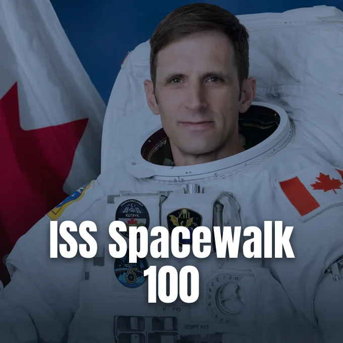 Astronaut Joshua Kutryk wearing a white spacesuit bearing the Canadian flag and mission patches