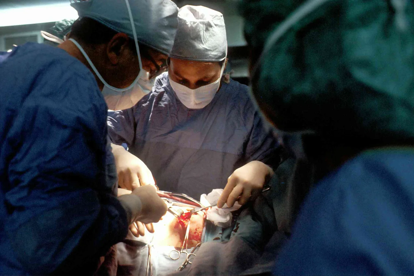 Surgeons performing an invasive tissue biopsy procedure