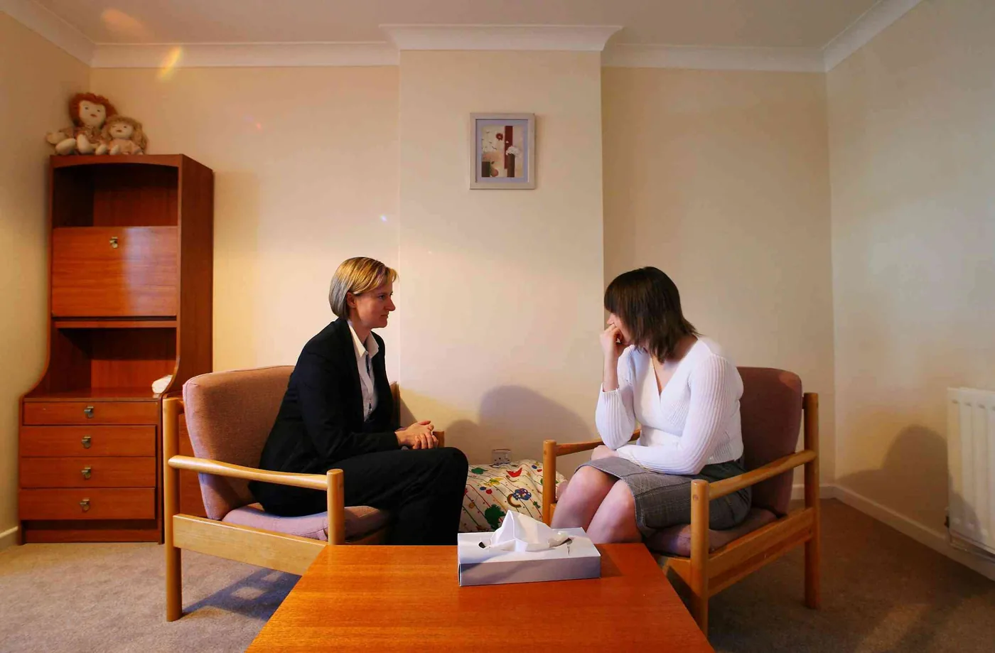Photograph of two women in discussion regarding social support and community responses.
