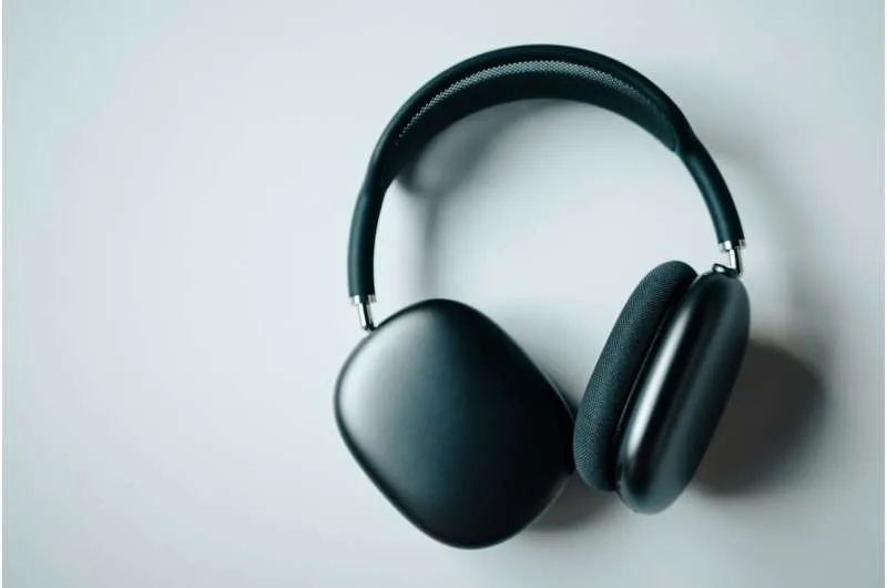 Audio headphones resting against a neutral background