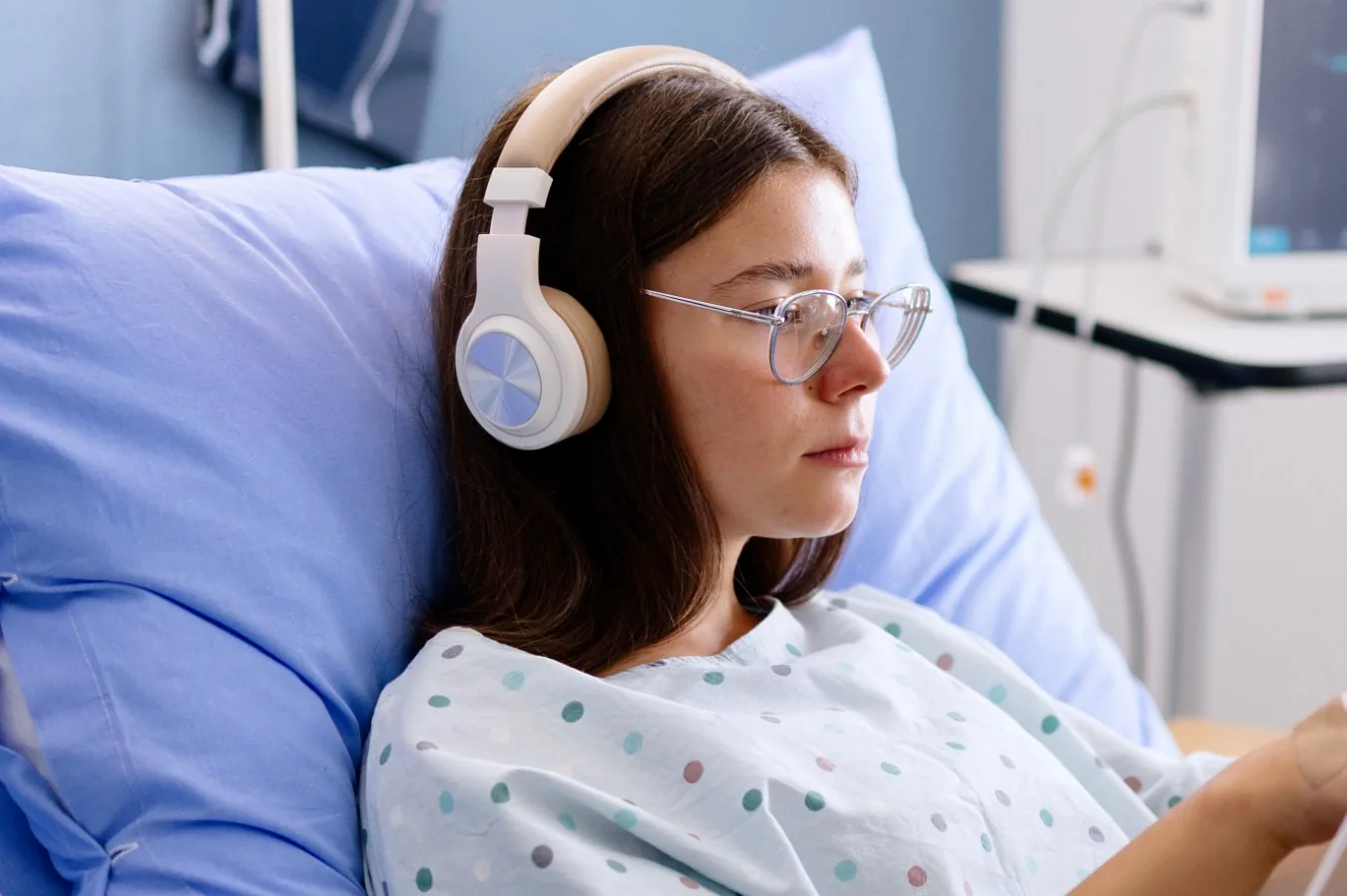 Over-ear headphones placed on a desk beside audio gear
