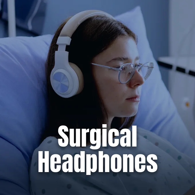 A young patient lying in a hospital bed wearing headphones and glasses.