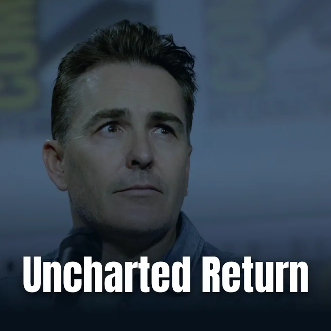 Actor Nolan North speaking at a panel event with a microphone visible in the foreground