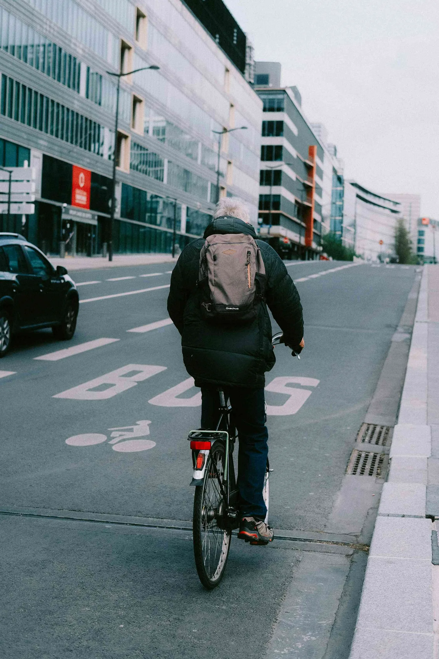 An older adult cycling through a neighborhood street, supporting older adult mobility.