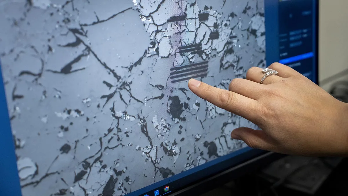 Microscopic view of a Martian meteorite sample displayed on a laboratory monitor.