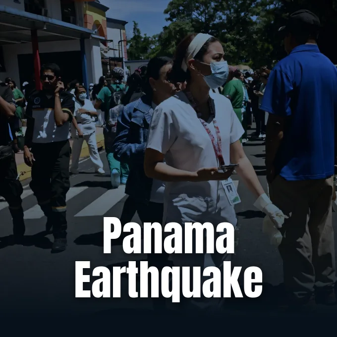 Healthcare workers and civilians gathered outdoors on a street following an earthquake evacuation.