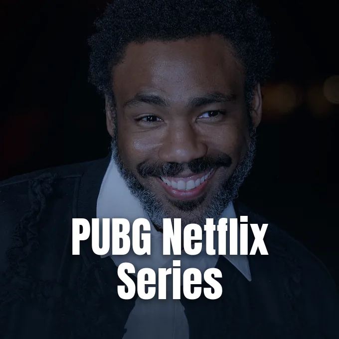 Donald Glover smiling warmly against a dark evening background in a formal outfit.