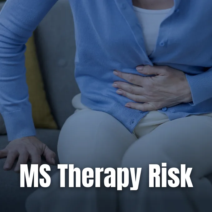 A woman sitting on a couch clutching her abdomen in pain due to stomach discomfort.