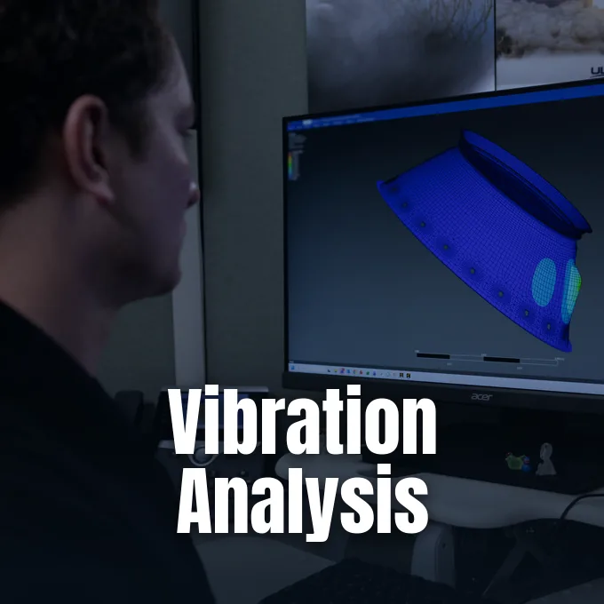 An engineer looks at a finite element mesh simulation of a rocket component on a computer monitor.