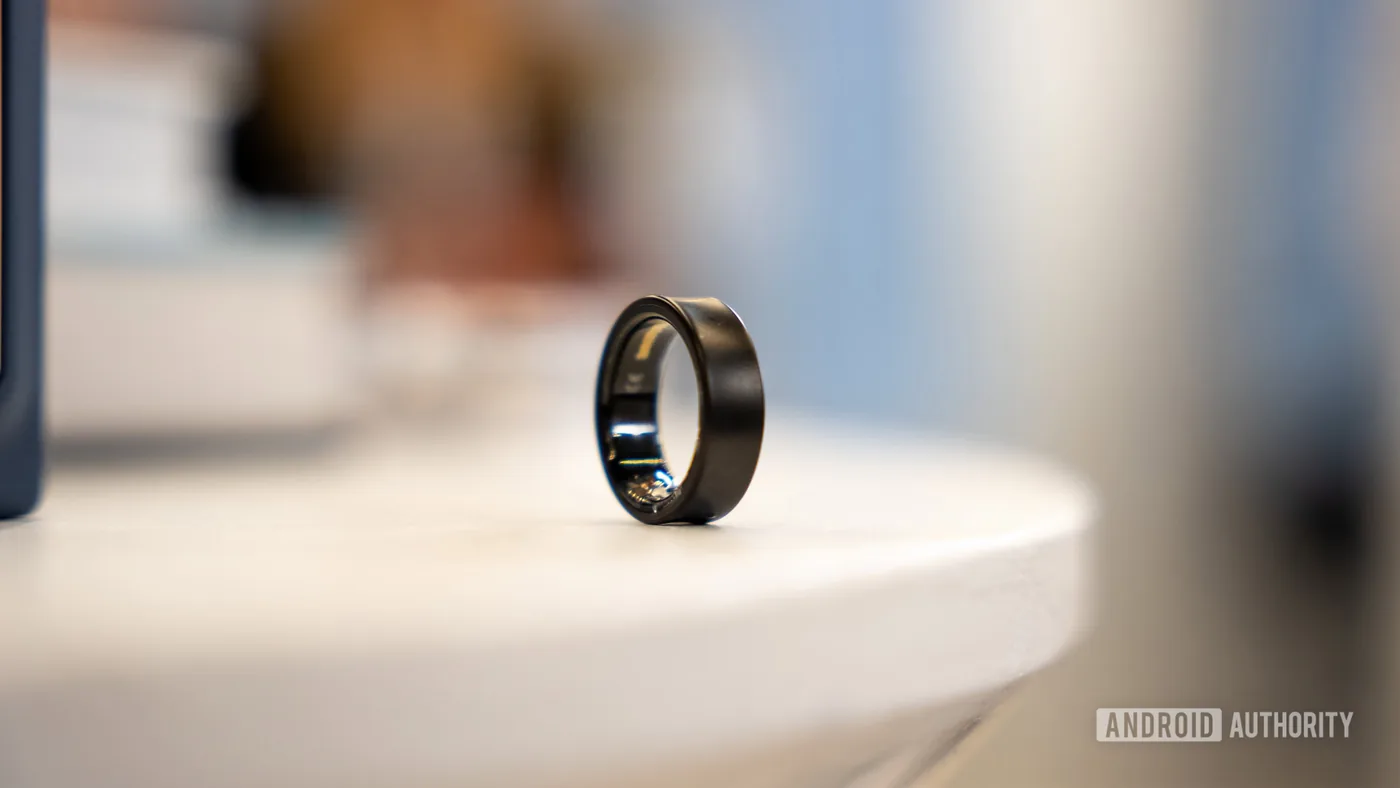 Titanium health tracking ring resting on a flat surface
