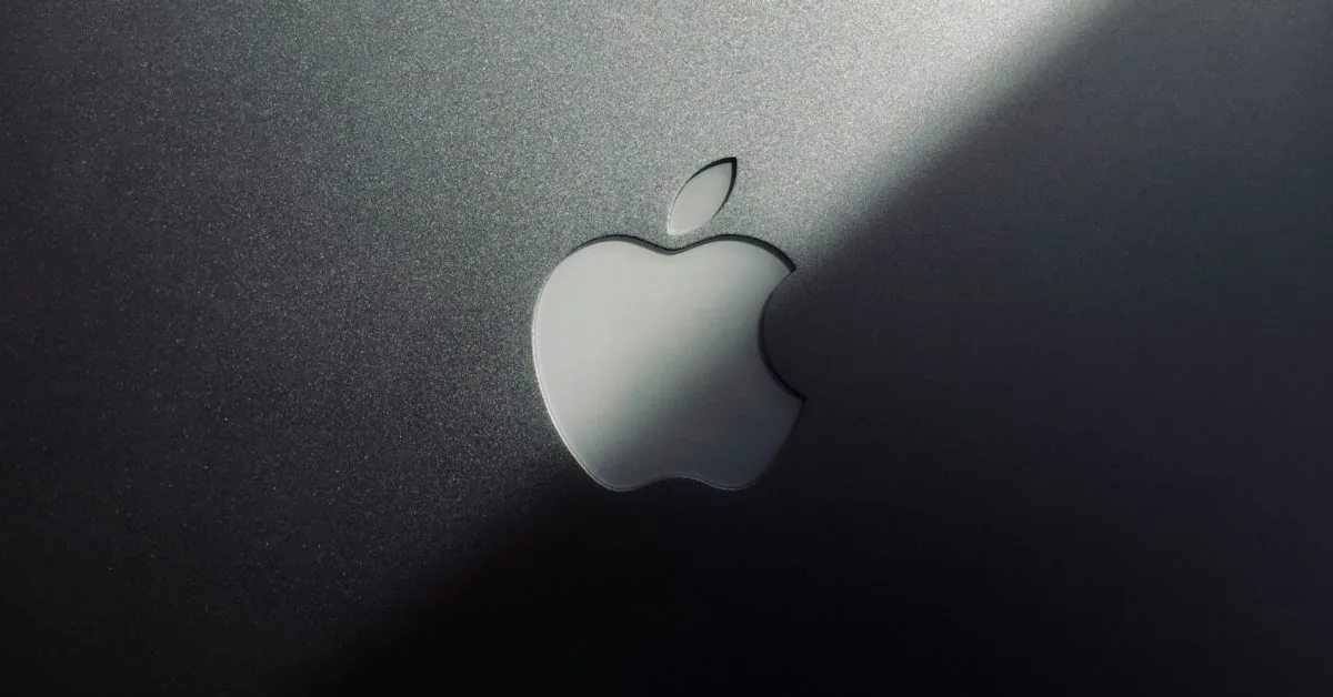 Brushed aluminum Apple logo cast with a drop shadow.