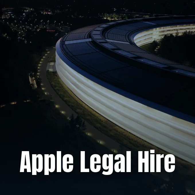 An aerial night view of the illuminated curved facade of the Apple Park headquarters building.