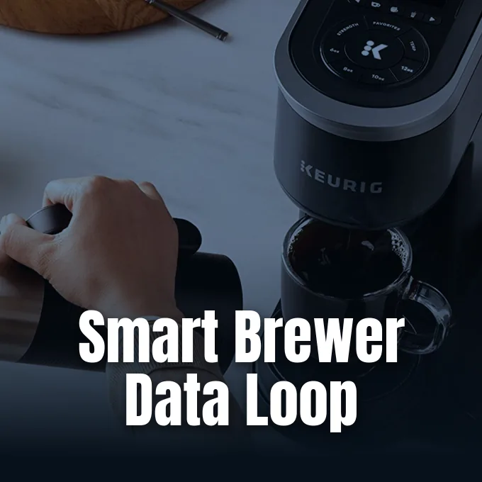 A person using a Keurig smart coffee maker with brewed coffee in a glass mug.