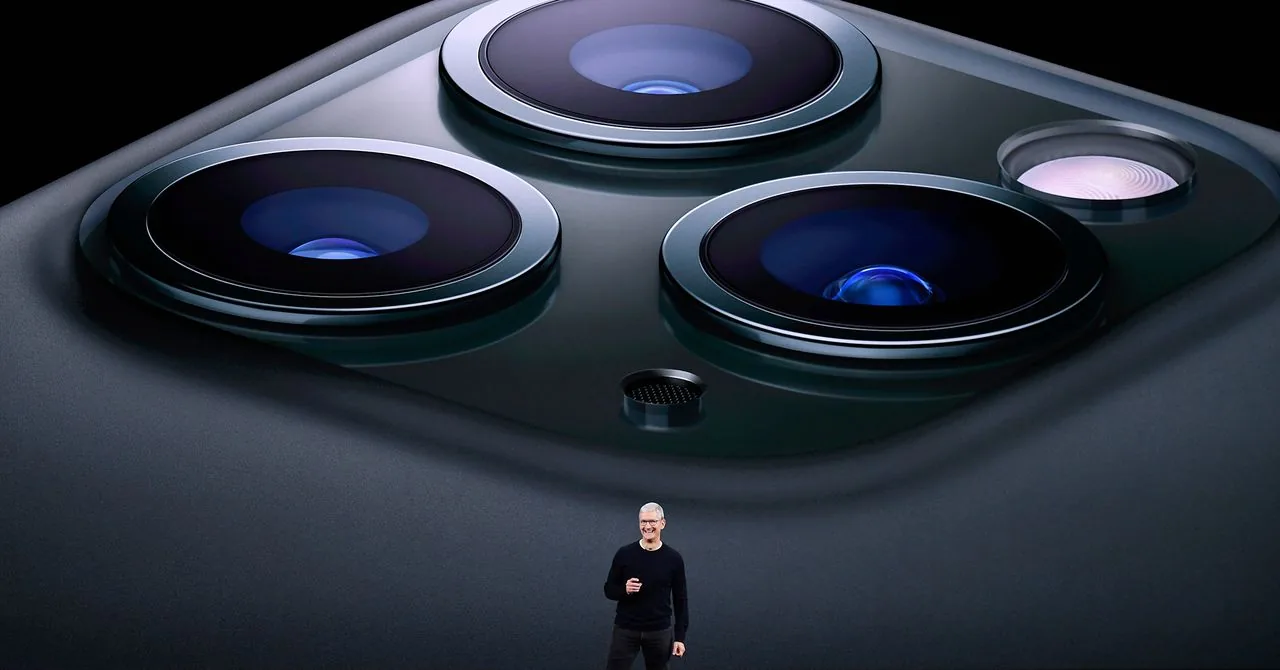Apple iPhone handset held in hand demonstrating directional device alignment.