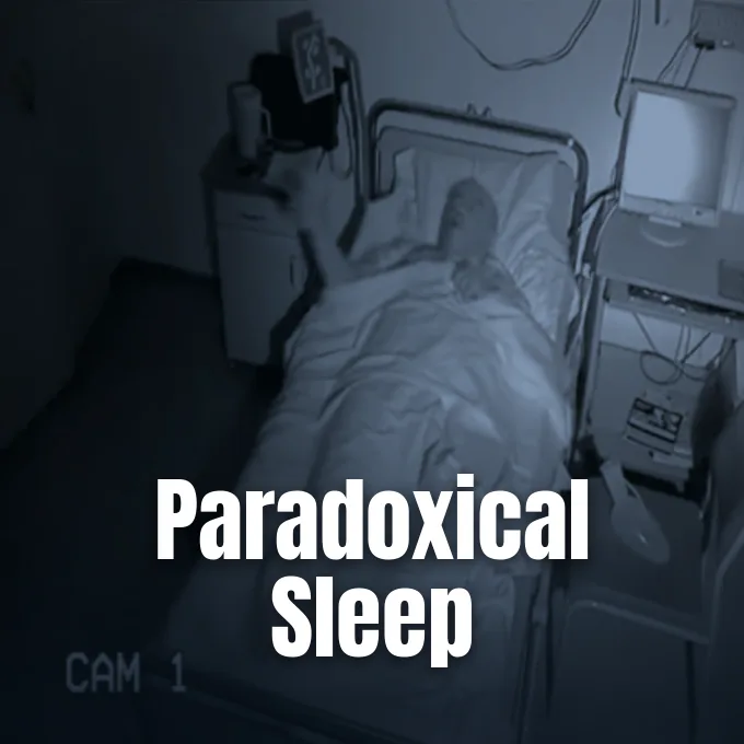 A patient lies in a hospital sleep study room monitored by medical equipment and an infrared camera.